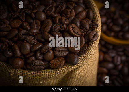 Frisch gerösteten Kaffeebohnen dunkel im Sack. Stockfoto
