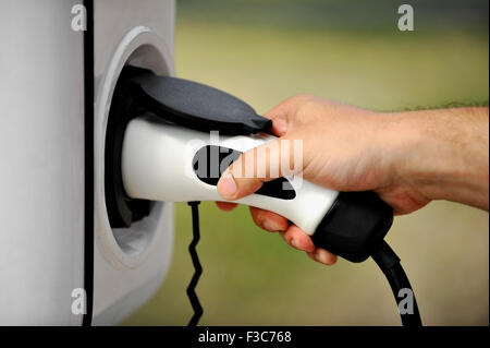 Hand, die eine elektrische Plug-in für Elektro-Auto aufladen Stockfoto