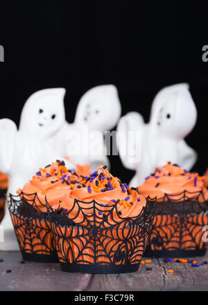 Festliche Halloween Cupcakes auf rustikalen Hintergrund mit Geistern Stockfoto