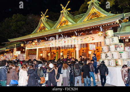 Japanischer Shinto-Schrein, Nishinomiya, 12:1 am Neujahrstag mit Tausenden von Menschen, die in der erschrockenen Gegend der Haiden, Halle, Schlange stehen, um zu beten. Nacht. Stockfoto