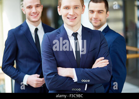Blick in die Kamera zwischen seinen Kollegen gut aussehend Unternehmensführer Stockfoto