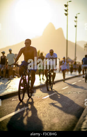 RIO DE JANEIRO, Brasilien - 11. Februar 2014: Radfahrer und Jogger teilen den Radweg neben Fußgängern in Ipanema. Stockfoto