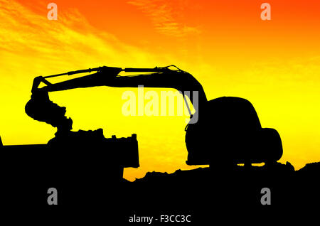 Silhouette Bagger Kipper LKW Kipper im Sandkasten auf Sonnenuntergang laden Stockfoto