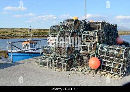 Hummer-Töpfe und Angelboote/Fischerboote in dem kleinen Hafen Inishnee Insel Conemmara County Galway Irland Stockfoto