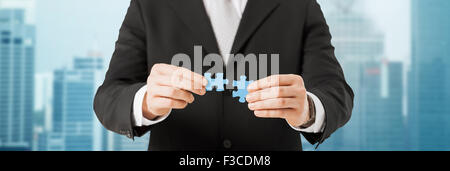 Mann versucht, die Puzzleteile über Stadt verbinden Stockfoto