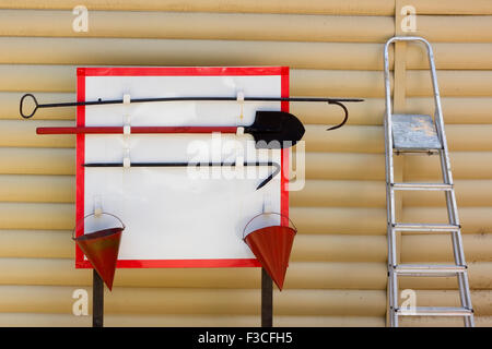 Feuer-Board mit roten Eimer, ein Haken, eine Schaufel und eine Leiter-Konzept. Stockfoto