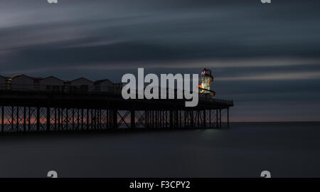 Ein Foto von Herne Bay Pier in Kent als die Sonne hatte gesetzt. Am Ende des Piers ist ein hell erleuchteter Helter Skelter. Stockfoto