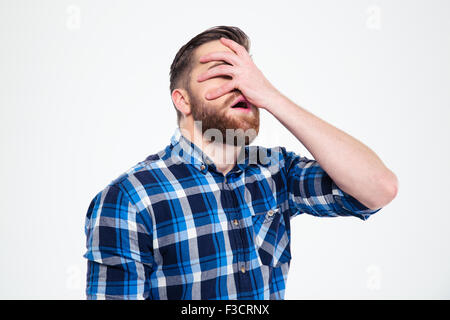 Porträt eines jungen Mannes bedeckte ihr Gesicht mit der Hand auf einem weißen Hintergrund isoliert Stockfoto