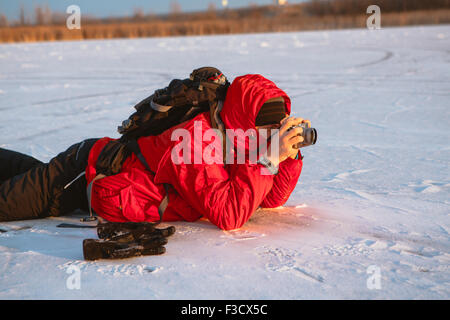 Fotografen Fotografieren am Ufer Flusses im winter Stockfoto