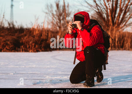 Fotografen Fotografieren am Ufer Flusses im winter Stockfoto