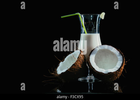 Pina Colada über schwarzen Hintergrund mit Kokosnuss. Stockfoto