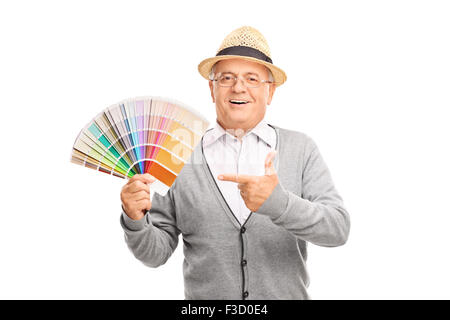 Senior Gentleman eine Farbe Palette Anleitung in einer Hand halten und mit den anderen isoliert auf weißem Hintergrund zeigt Stockfoto