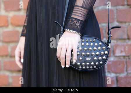 Frau posiert für die Fotografen vor Fendi-Show mit schwarz rote Valentino Tasche tagsüber Mailand Fashion Woche Stockfoto