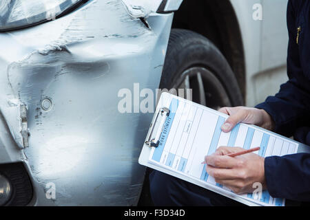 Automechaniker Workshop Inspektion Schäden an Fahrzeug und Reparatur Kostenvoranschlag ausfüllen Stockfoto