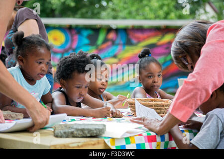 Detroit, Michigan - Kinder arbeiten an einem Kunstprojekt in einem Park von drei Meilen Block Club auf drei Baulücken erstellt. Stockfoto