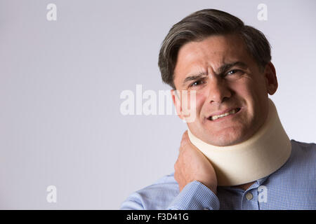 Studioaufnahme des Menschen Schmerzen tragen Neckbrace Stockfoto