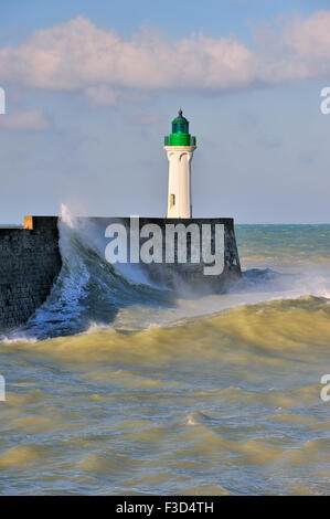 Welle stürzt in Mole mit Leuchtturm bei rauer See an Saint-Valéry-En-Caux, Normandie, Frankreich Stockfoto