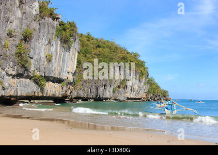 El Nido, Philippinen - Januar 11,2015: Tropical Beach in El Nido, Palawan, mit einem Boot Mann auf einem typischen Philippinos Boot Stockfoto