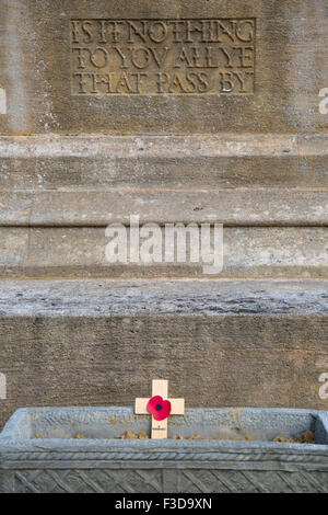 Einzel-Mohn und Holzkreuz auf einem Kriegerdenkmal in einer englischen Stadt. Stockfoto