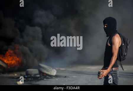 (151005)--RAMALLAH, 5. Oktober 2015 (Xinhua)--A palästinensische Demonstranten hält Steinen auf israelische Soldaten bei Zusammenstößen in der Nähe der jüdischen Siedlung Beit Eil, in der Nähe von der Westbank Ramallah am 5. Oktober 2015 zu werfen. (Xinhua/Fadi Aruri) Stockfoto