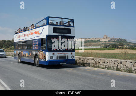 Ein Volvo Citybus mit Alexander Karosserie reist in Richtung Handwerksdorf am Ta'Qali. Im Hintergrund ist die Stadt Mdina Stockfoto