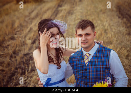 Braut und Bräutigam in der Nähe von Heu auf einem ländlichen Gebiet Stockfoto