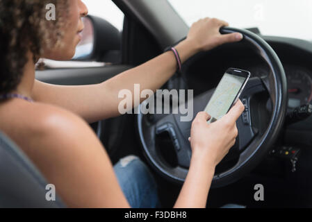 Junge Frau SMS während der Fahrt Auto Stockfoto