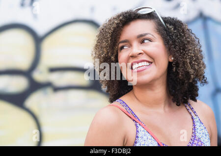 Porträt der lächelnde junge Frau mit lockigem Haar Stockfoto