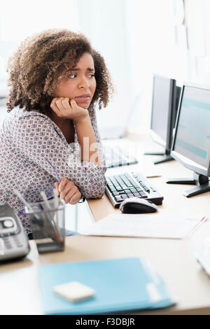 Junge Frau, die im Büro arbeiten Stockfoto