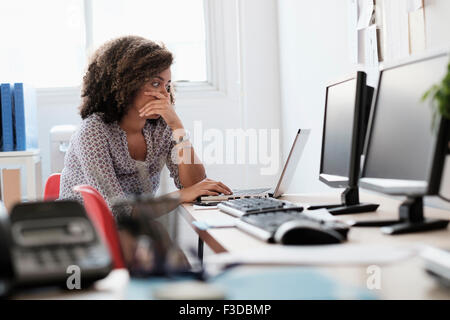 Junge Frau, die im Büro arbeiten Stockfoto