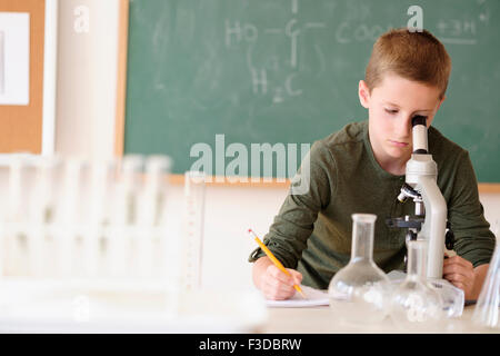 Jungen (8-9) suchen durch Mikroskop Stockfoto