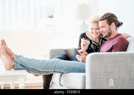 Paar mit tablet-pc auf sofa Stockfoto