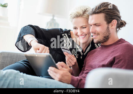 Paar mit tablet-pc auf sofa Stockfoto