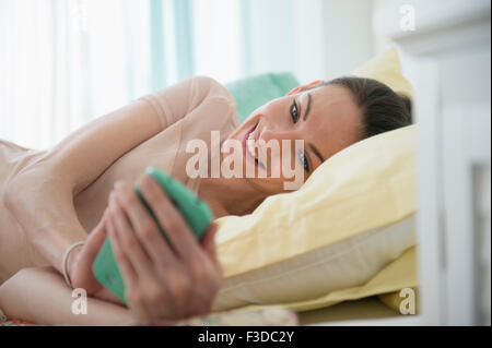 Frau im Bett mit Smartphone Stockfoto