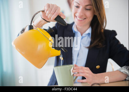 Frau, die Zubereitung von Tee im Büro Stockfoto