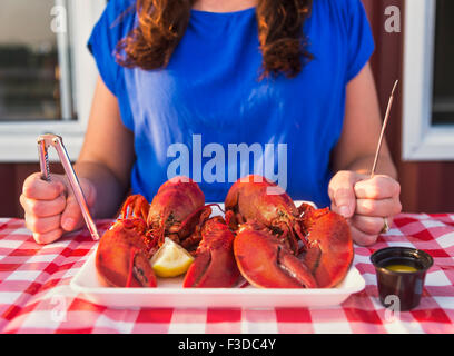 Ansicht der Tabelle mit Lobster Essen und Frau zu essen vorbereiten Stockfoto