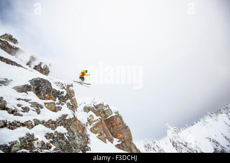 Skifahrer vom felsigen Berg springen Stockfoto