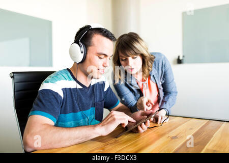 Mann mit Frau seine Musik auf Smartphone Stockfoto