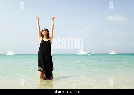 Frau mit am Strand erhobenen Armen Stockfoto