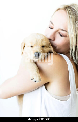 Studioaufnahme von Golden Retriever Welpen mit Besitzer Stockfoto