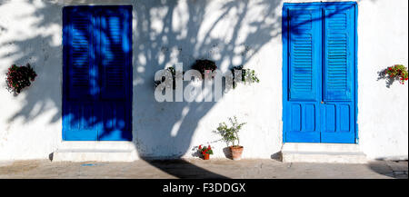 typische und kultigen blauen Holztür gegen klare weiße Wand in dem Abendlicht Stockfoto