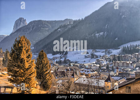 Panorama von St. Ulrich, italienisches Dorf in Dolomiten Alpen in Italien: Tal der Häuser und Gebäude mit schneebedeckten Gipfeln und Koniferen im Hintergrund Stockfoto