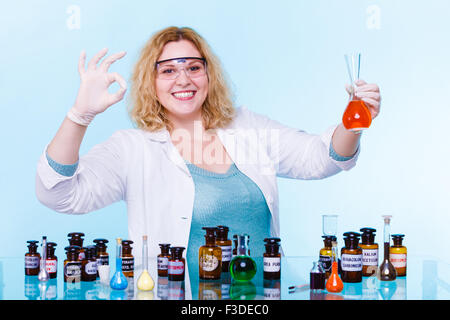 Experimente im Labor. Glücklich Chemiker Frau oder Student Mädchen wissenschaftlicher Mitarbeiter mit chemischen Glaswaren Test Kolben machen o Stockfoto