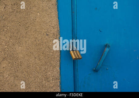 Goldenen Vorhängeschloss auf ein Gebäude blaue Tür befestigen Stockfoto