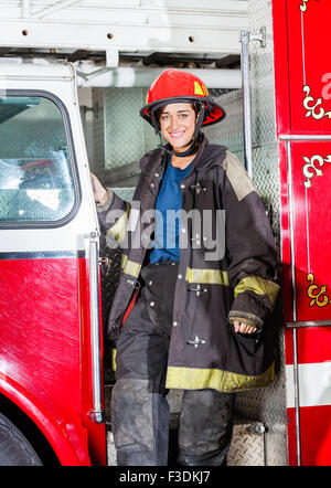 Glücklich Feuerwehrmann In Uniform stehen auf LKW Stockfoto