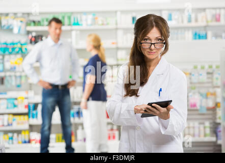 Weiblichen Chemiker mit Digital-Tablette in Apotheke Stockfoto