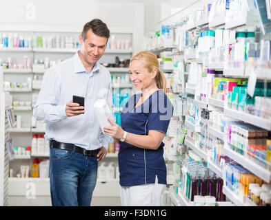 Zufriedener Kunde mit Handy beim Apotheker Holding Produ Stockfoto