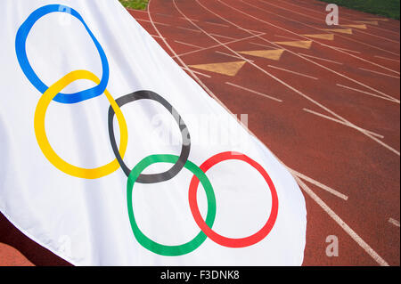 NEW YORK CITY, USA - 30. August 2015: Olympische Flagge Wellen über die Fahrspuren von einer traditionellen roten Tartanbahn laufen. Stockfoto