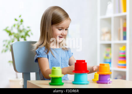 junge Mädchen spielen mit Spielzeug drinnen Stockfoto