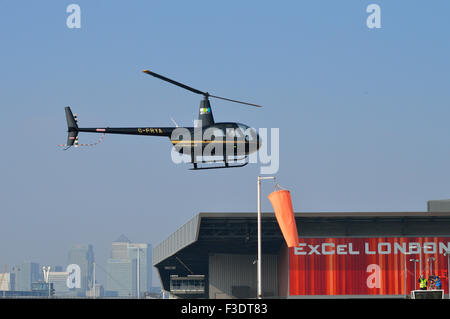 Robinson R44 G-FRYA von A2B Aero Limited betrieben kommt im Londoner Excel Exhibition Centre zur Teilnahme an Helitech landen Stockfoto